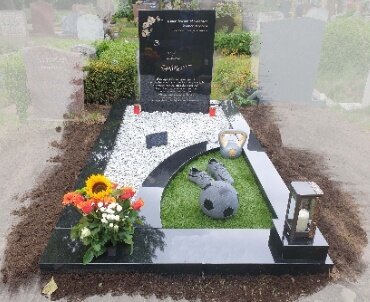 grafsteen met granieten voetbalschoenen