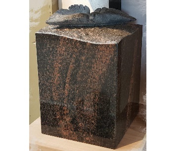Urn van graniet met gekapte vogel uit steen