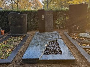 Grafsteen met brons beeld zittend paar